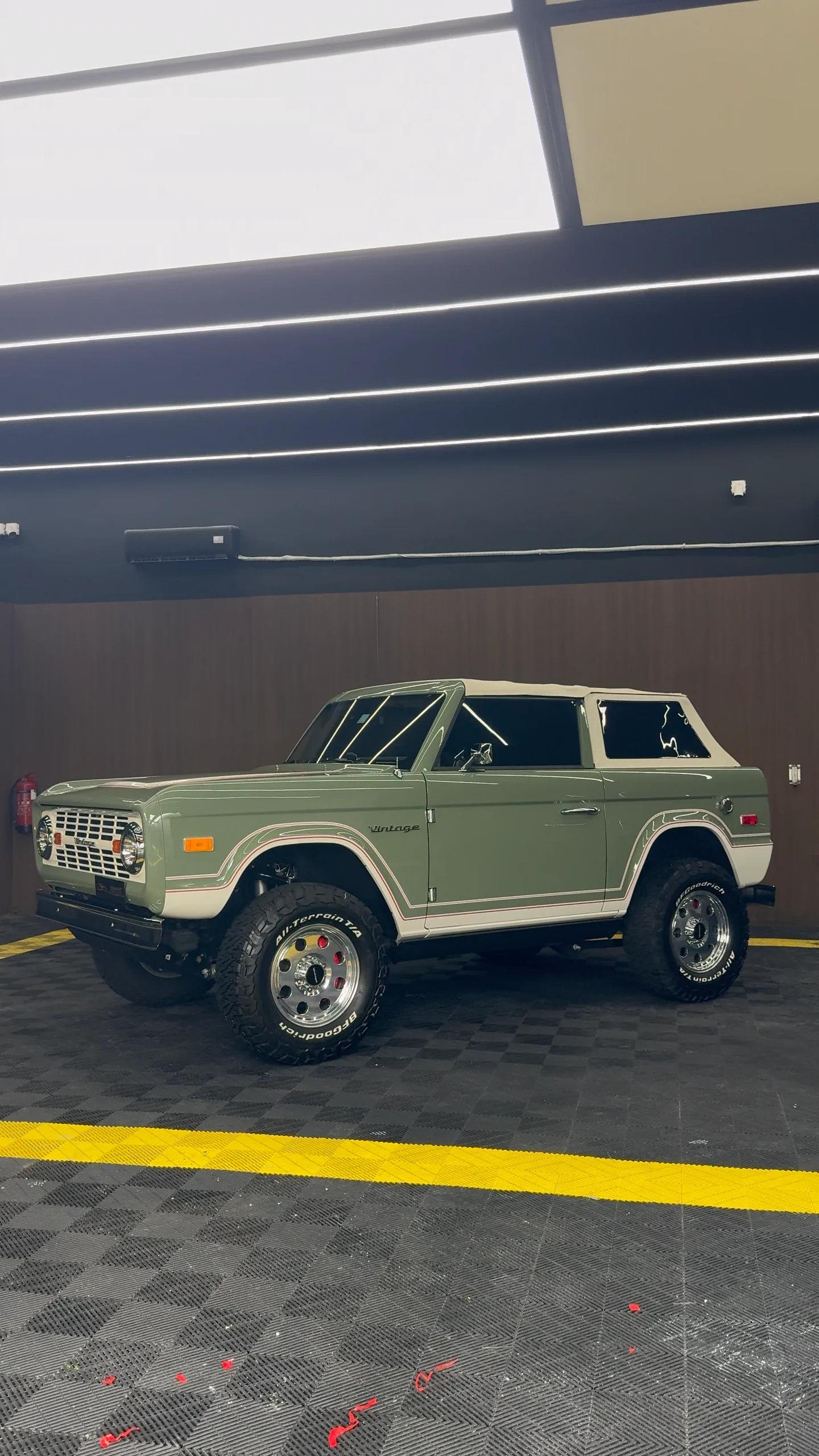 Side view of a sage green classic Ford Bronco at the WrapME studio