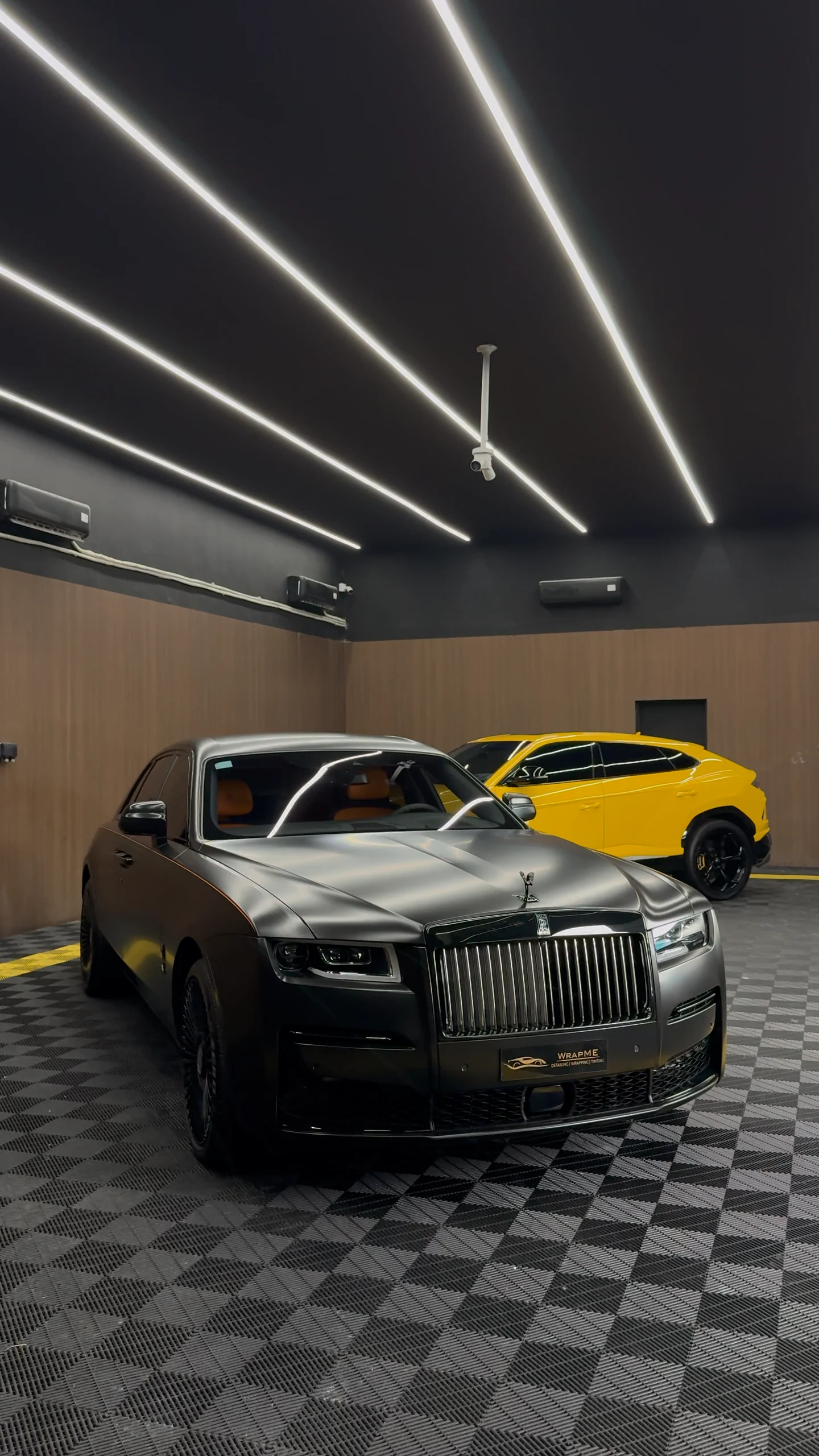 Satin grey Rolls-Royce Ghost with a yellow Lamborghini Urus at the WrapME studio